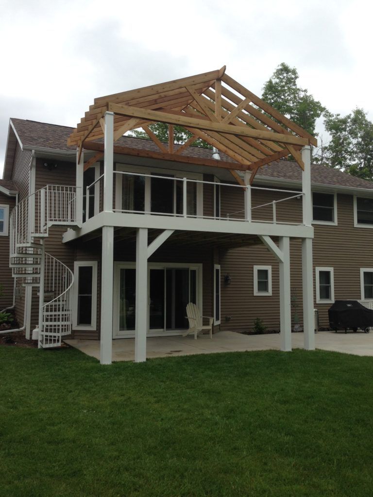 A house with a large deck and stairs and wooden roof