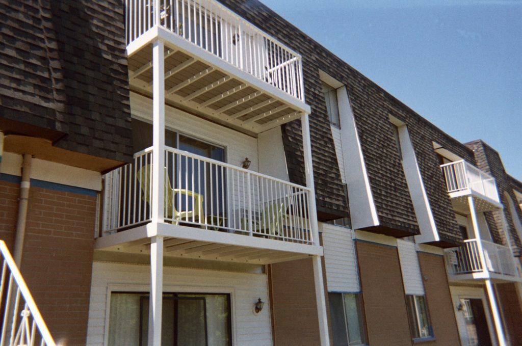 A brick apartment building with a balcony and stairs