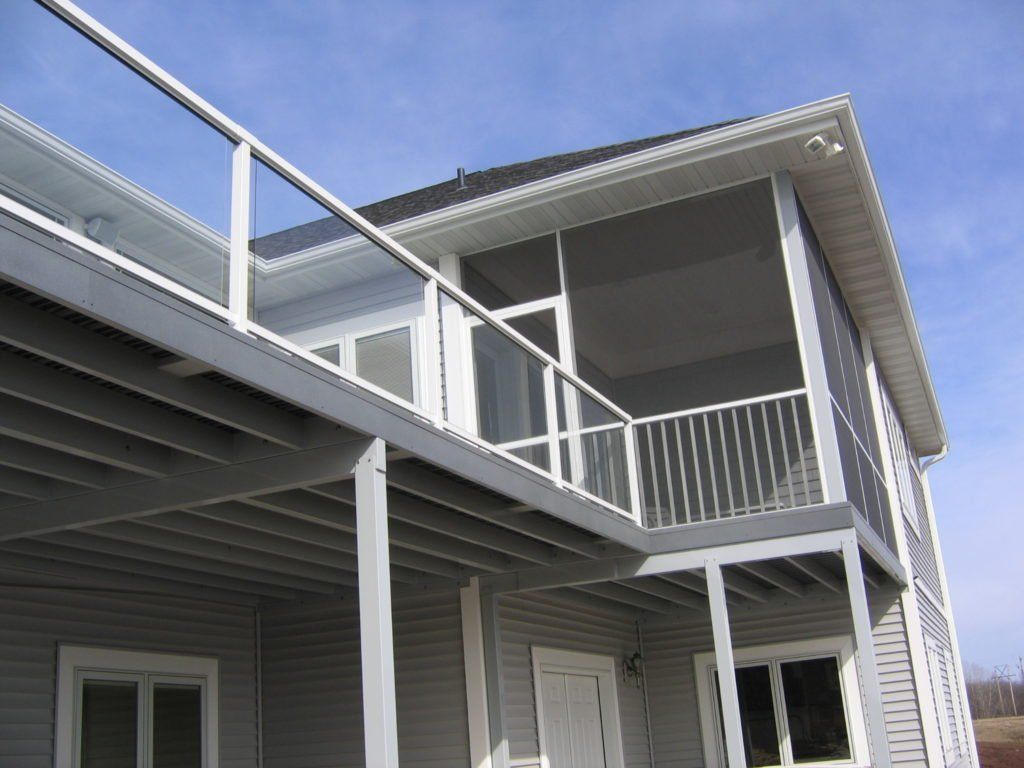 A house with a deck and glass railing panels 