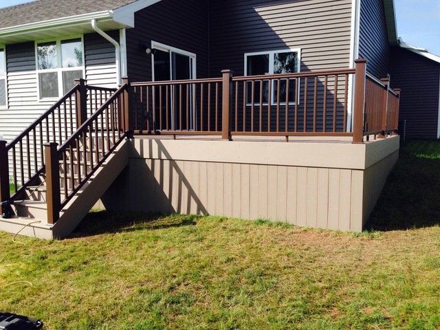 A house with a deck and stairs in front of it