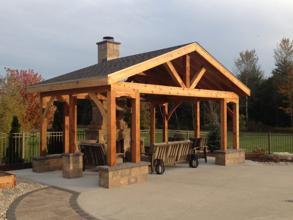 A large wooden pavilion with a brick patio in front of it