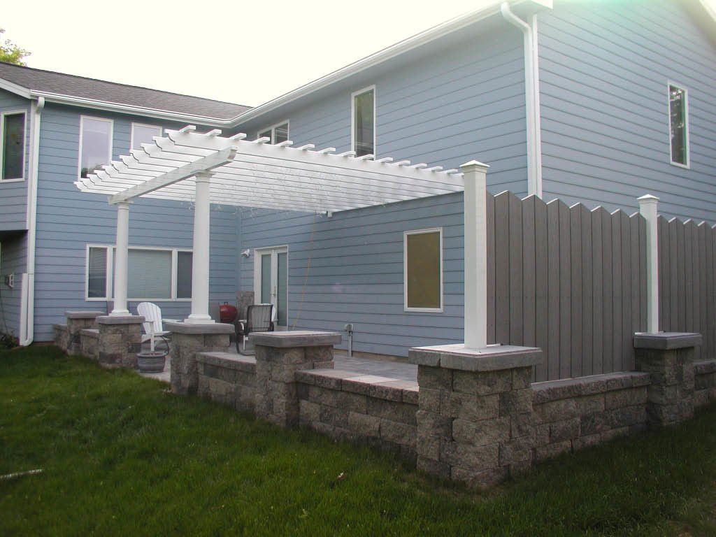 A house with a pergola and a fence 