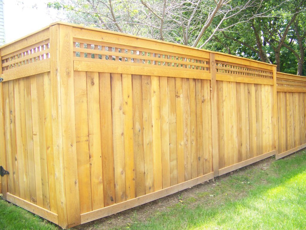 A wooden fence is sitting on top of a lush green lawn.