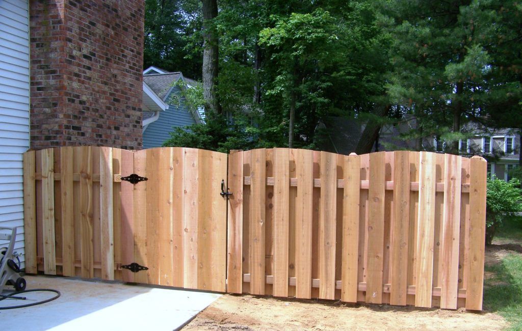 A wooden fence with a gate in the backyard of a house