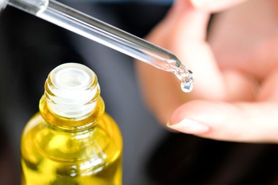 man taking a drop of liquid on his finger