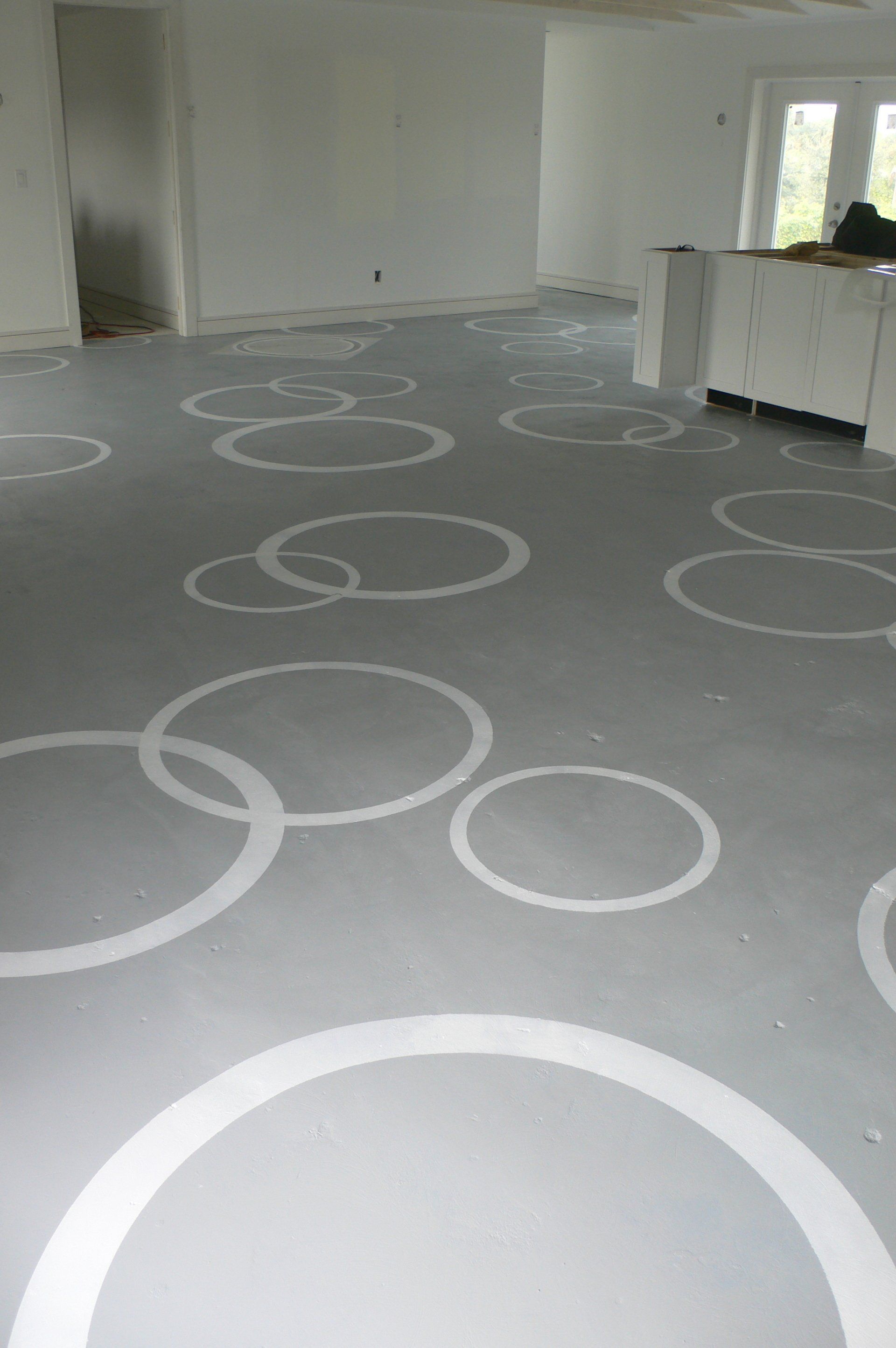 Gray floor with white overlapping circles in an empty, light-filled room.