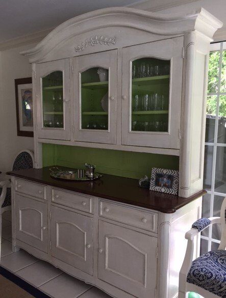 White painted hutch with glass-fronted cabinet doors, dark wood counter, and green interior.