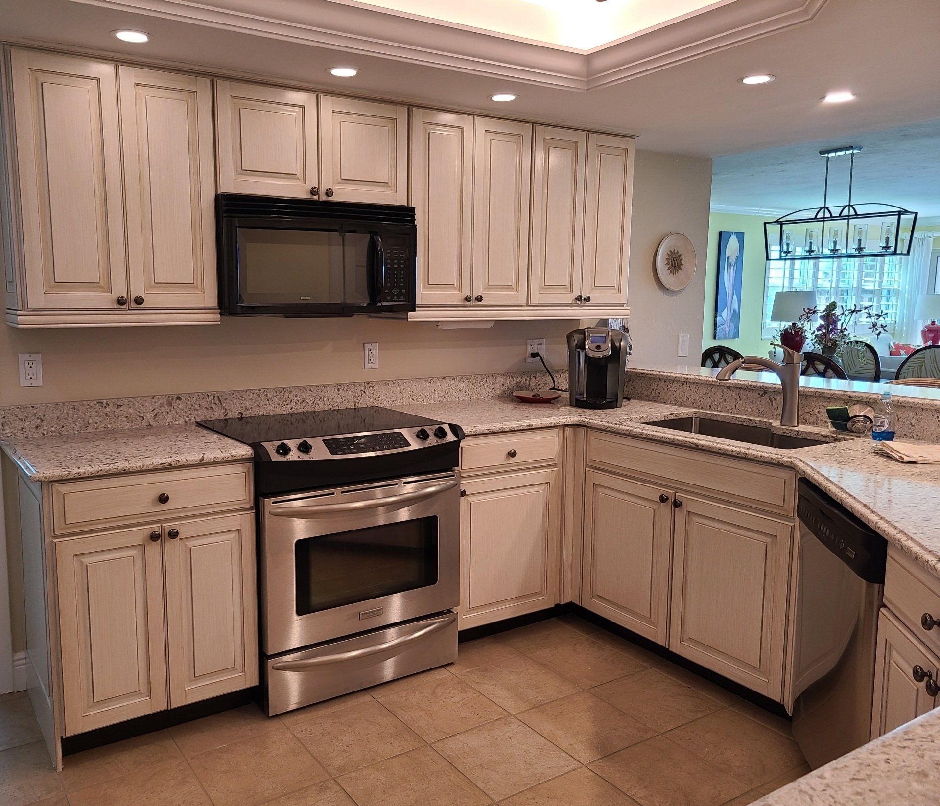 Cream-colored kitchen cabinets with granite countertops and stainless steel appliances.