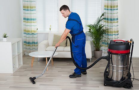 Male worker cleaning floor with vacuum cleaner Male worker cleaning floor with vacuum cleaner