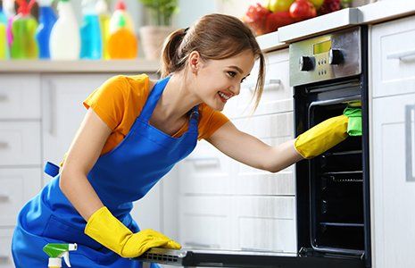 Woman washes an oven in the kitchen Woman washes an oven in the kitchen