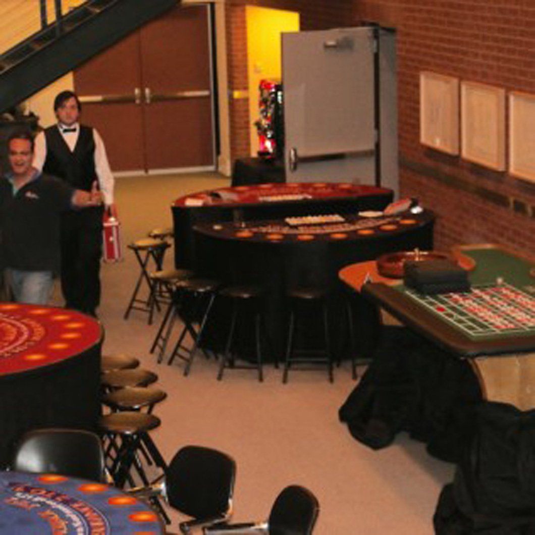 A man in a tuxedo stands in front of a casino table