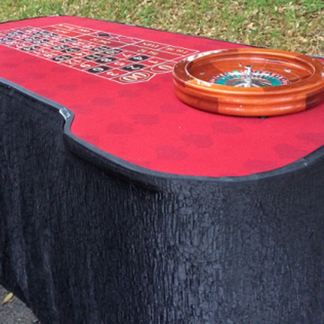 A roulette wheel is sitting on top of a red table.