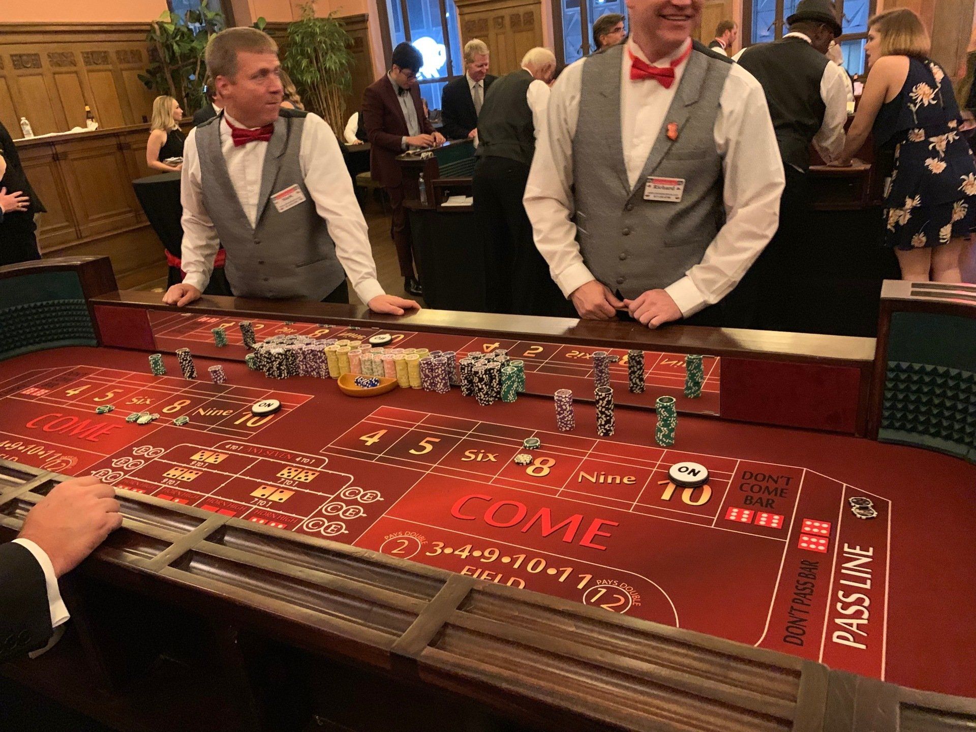 Two men are standing at a roulette table in a casino.