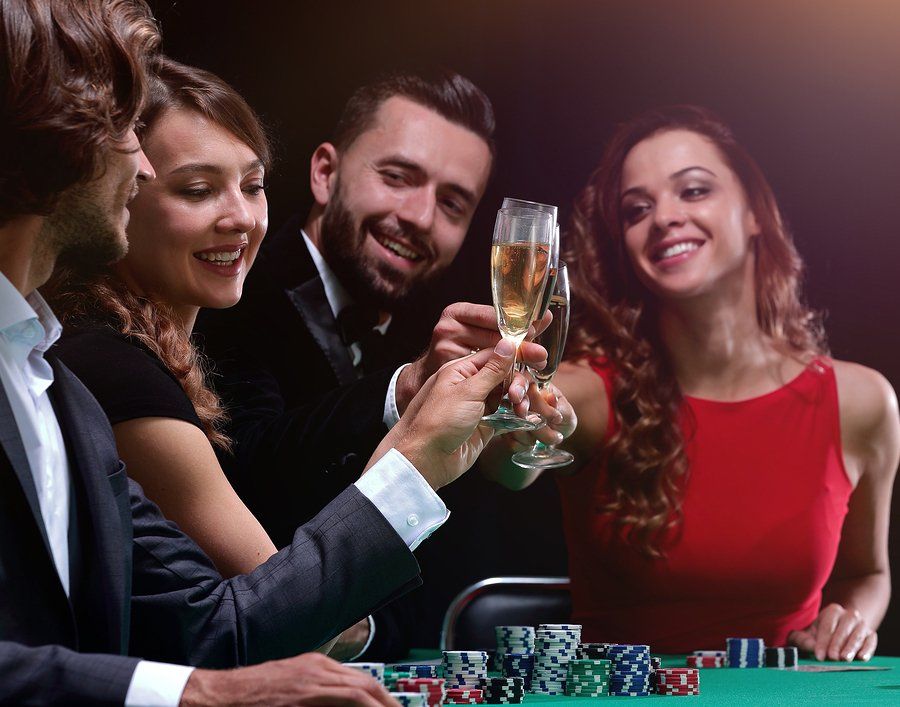 A group of people are toasting with champagne at a poker table.