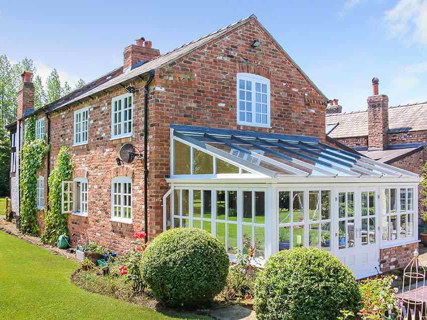 White Trim Home Conservatory Added to Brick Home. Installed by Holt Orangeries