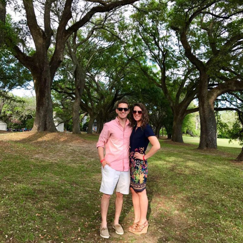 A man and a woman are posing for a picture in a park.