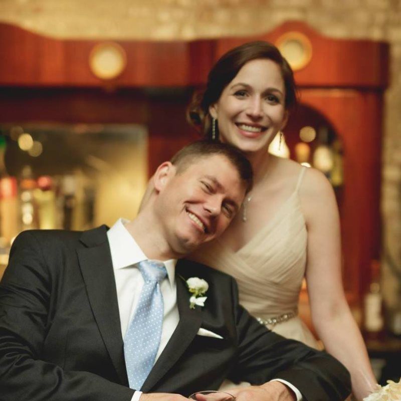 A man in a suit and tie is sitting next to a woman in a dress