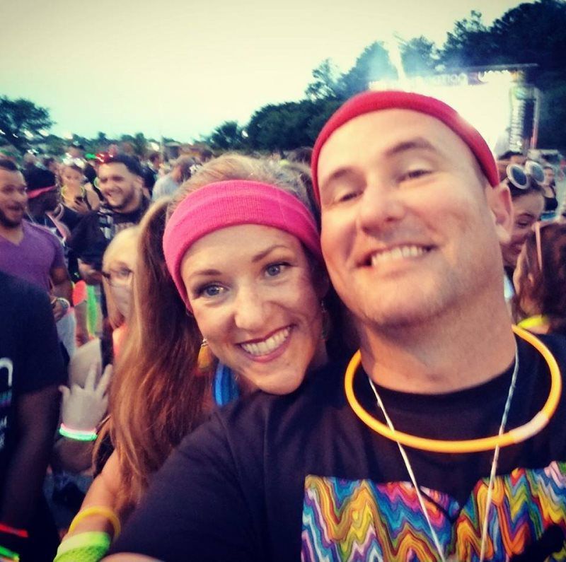 A man and a woman are posing for a picture in front of a crowd
