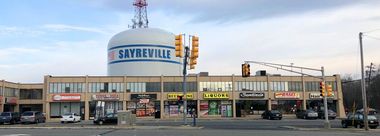 A commercial building with a Sayreville water tower in the background.