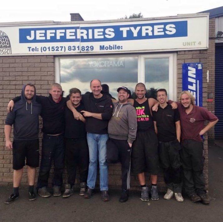 A group of men pose in front of a jefferies tyres sign