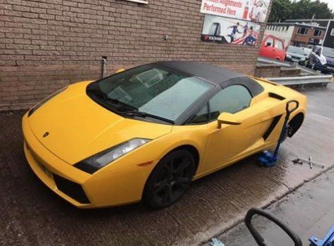 A yellow lambo having tyres changed