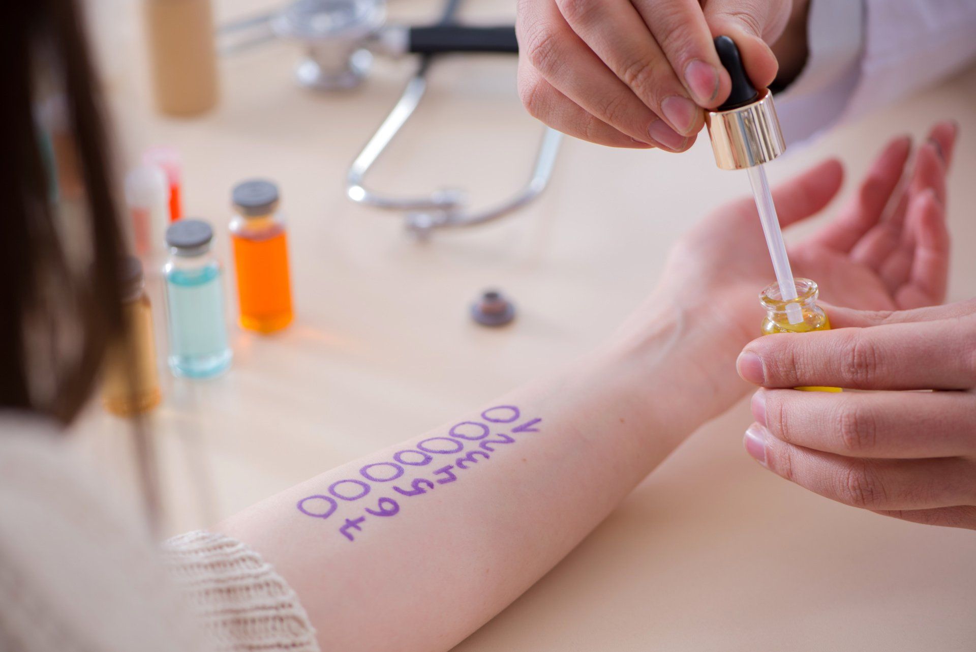 A doctor is applying a drop of liquid to a patient 's arm.