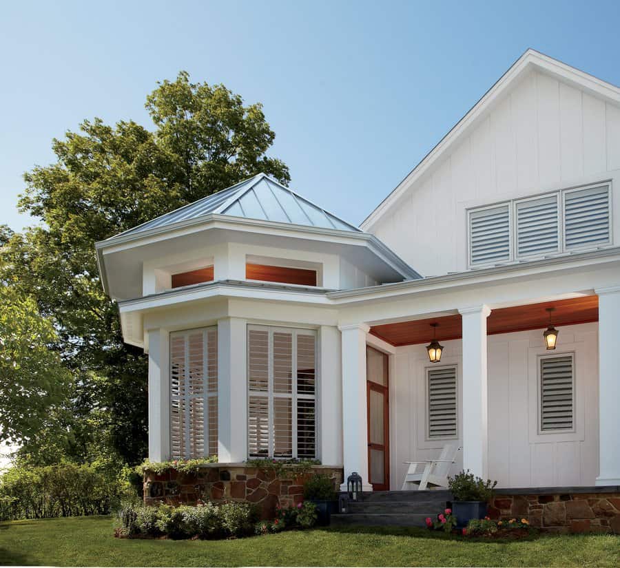 Backyard view of a house with Hunter Douglas Palm Beach Shutters