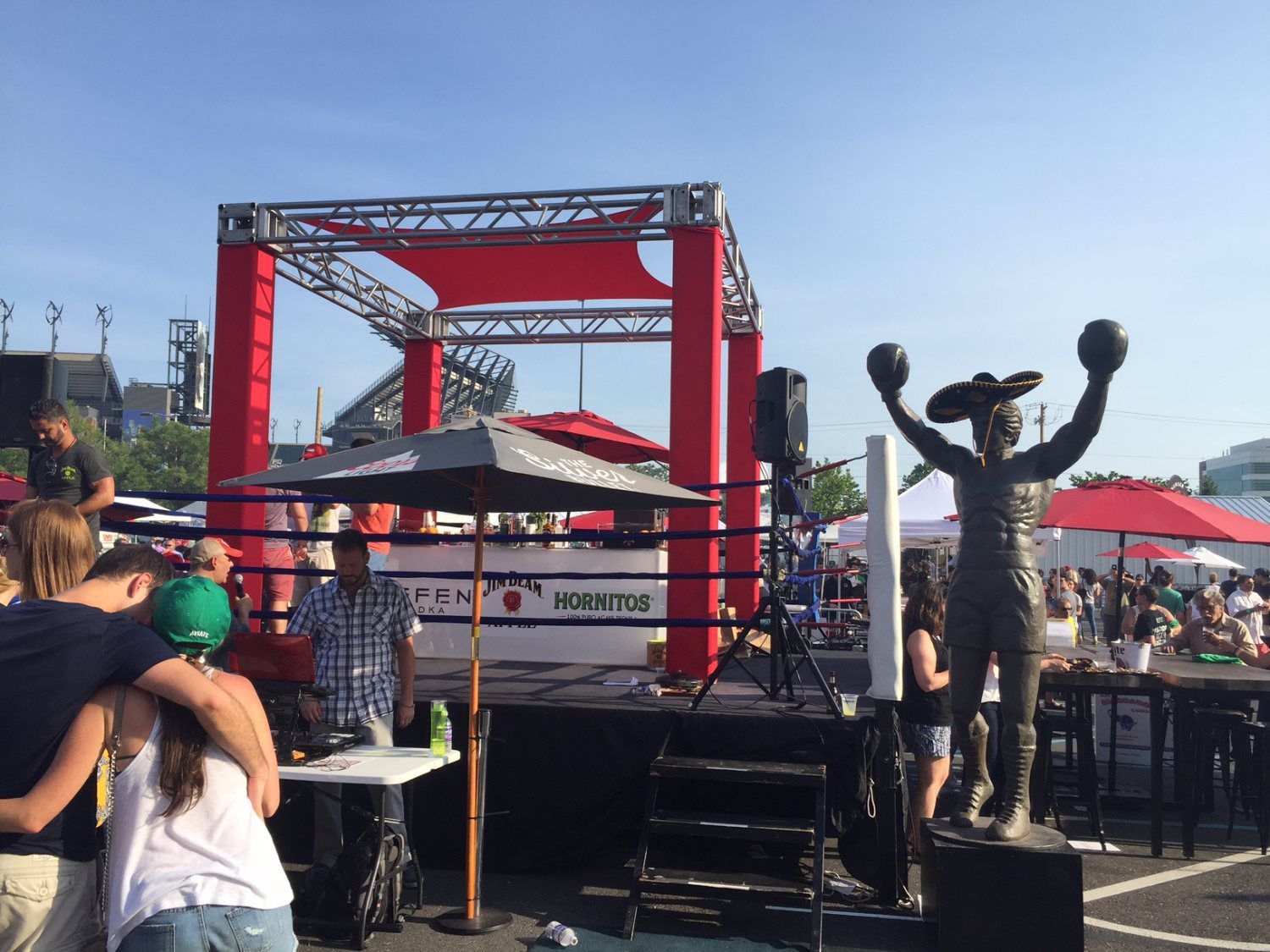 A statue of a man holding boxing gloves in front of a boxing ring