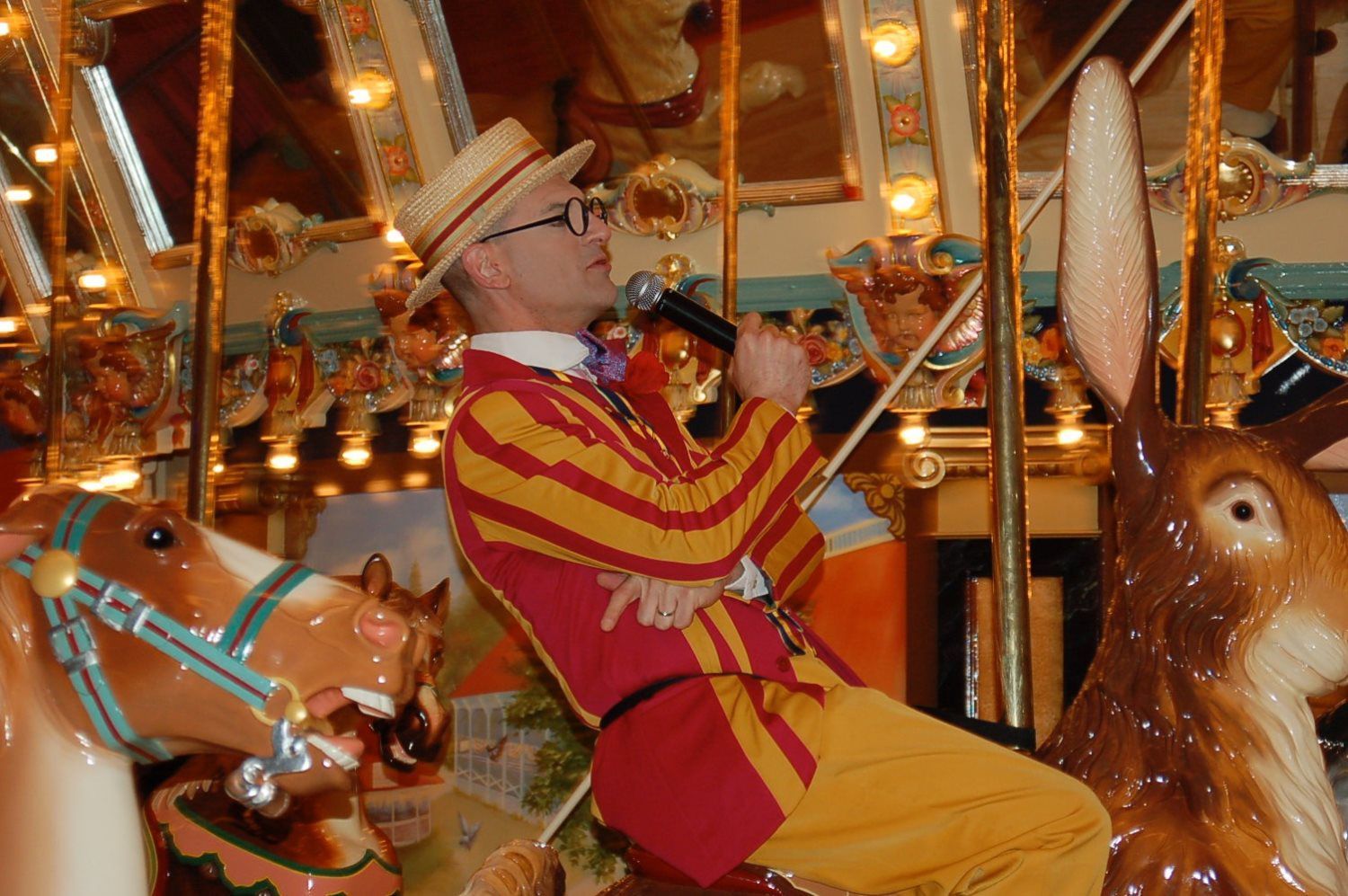 A man is playing a violin on a merry go round