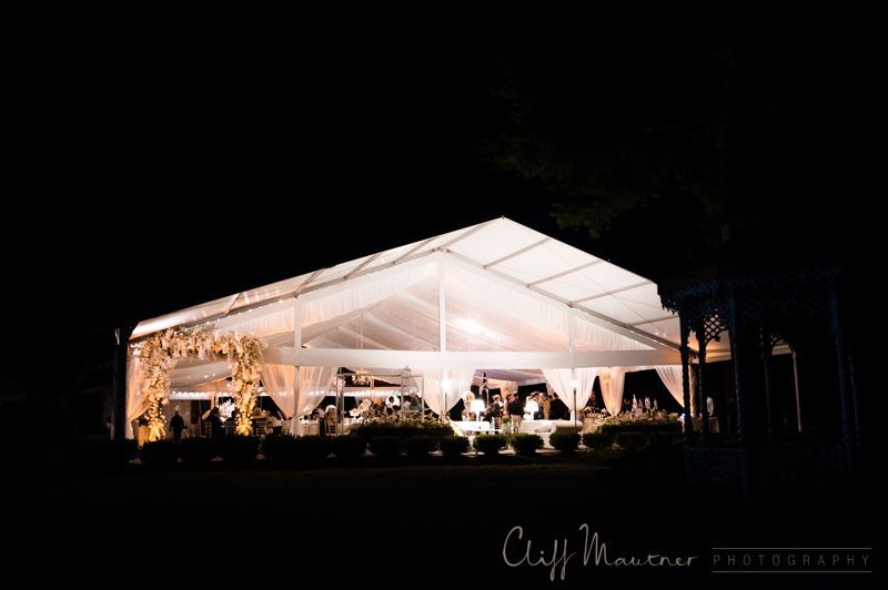 A large white tent is lit up at night.