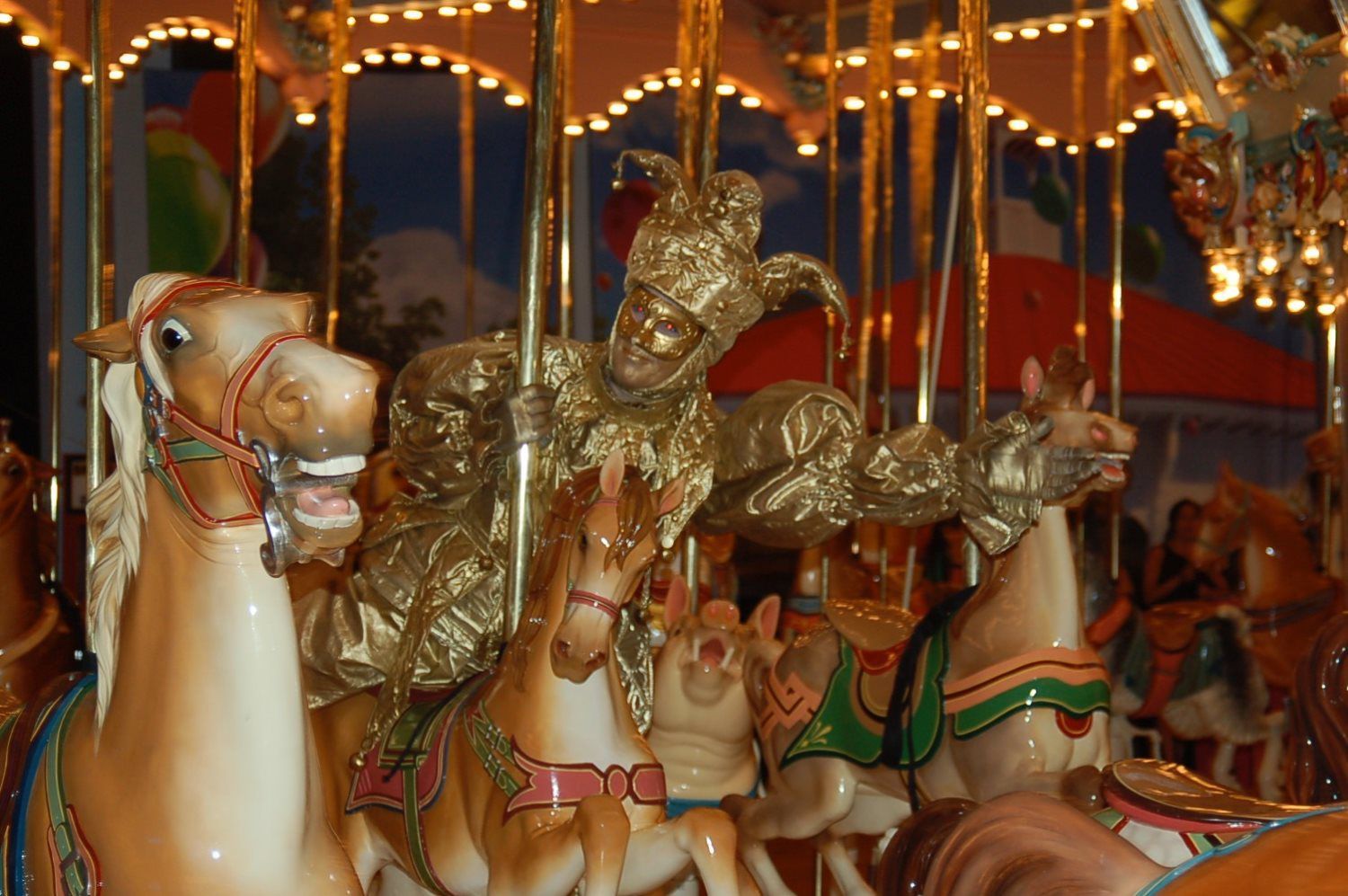 A carousel with horses and a jester on it