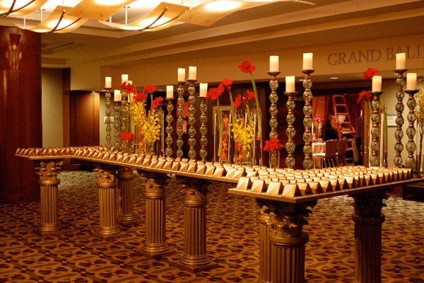 A long table with candles and flowers in front of a sign that says grand ballroom