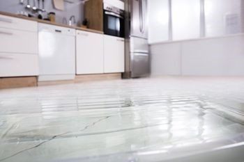 a kitchen with a flooded floor and a sink .