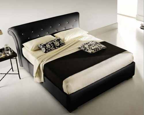 un letto di colore nero e accanto un comodino