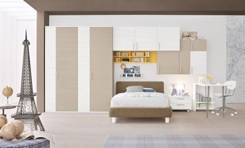 una cameretta con un letto e degli armadi beige e bianchi