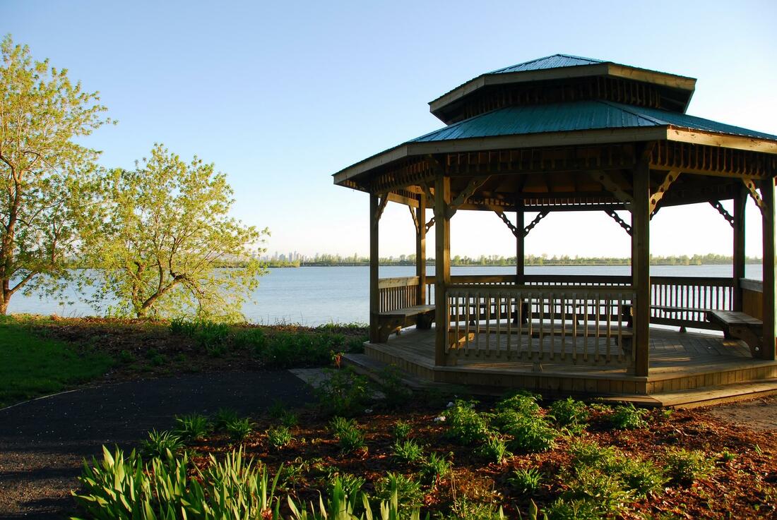 A gazebo overlooking a lake with trees in the background