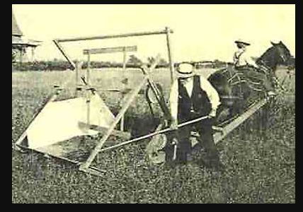 Man operating a horse-drawn machine, while another rides the horse in a field. Black and white photo.