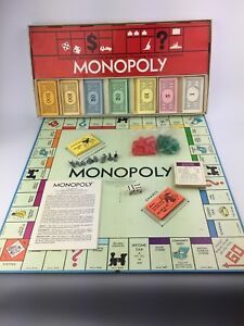 Monopoly board game set on a light blue surface with cards, dice, and game pieces.