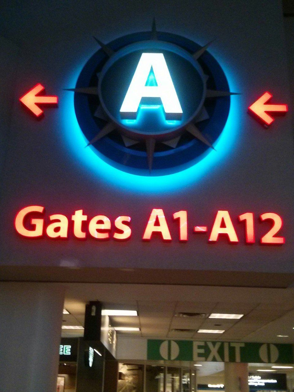 Airport sign for Gates A1-A12 with a large illuminated 