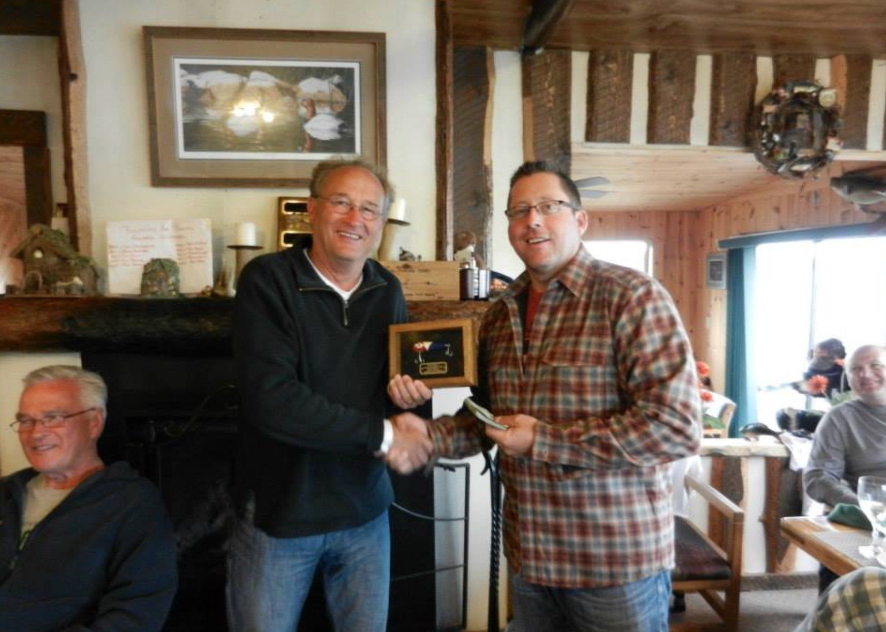 Fishermen shaking hands in the dining room at Oak Lake Lodge.