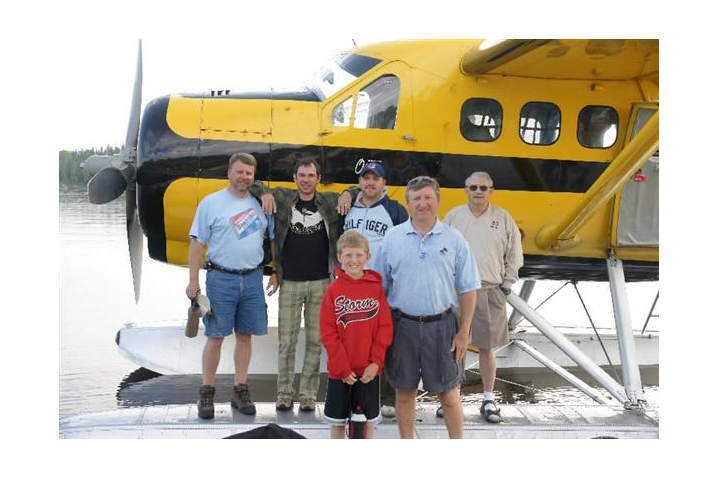 A family on the dock at a fly-in fishing lodge called Oak Lake Lodge.