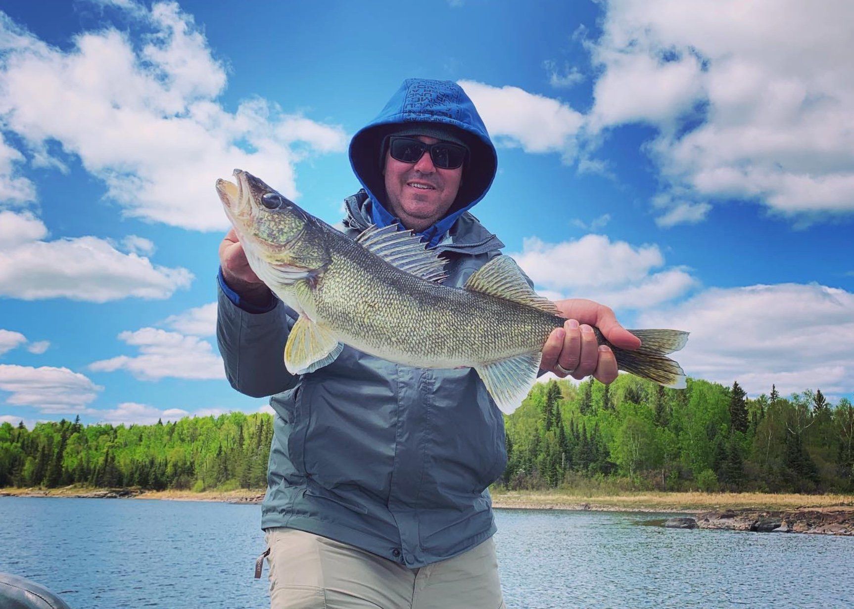 man holding a walleye fish.