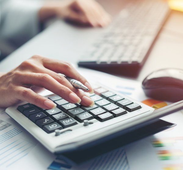 Woman using a calculator — Long Beach, MS — Mallette Accountants LLC Woman using a calculator — Long Beach, MS — Mallette Accountants LLC