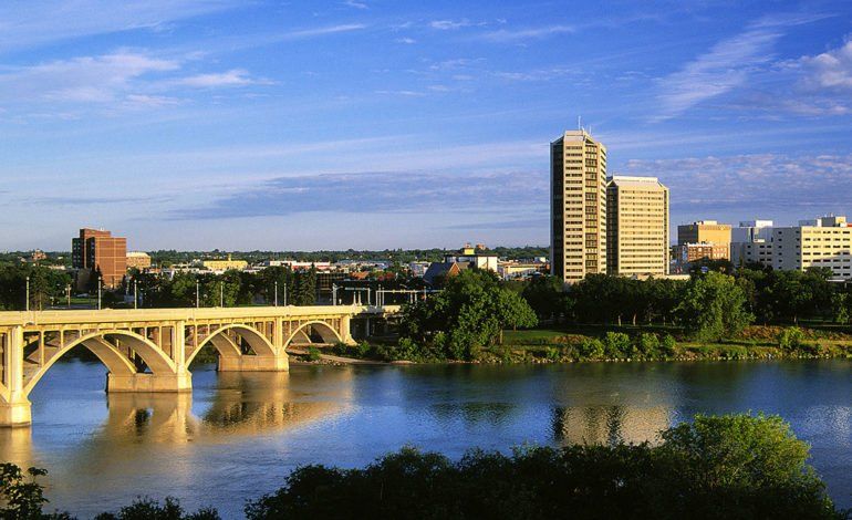 A bridge over a river with a city in the background.