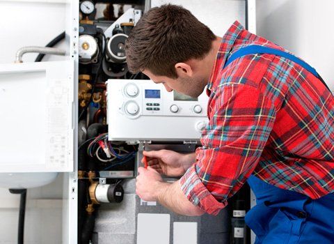 A Plumber Fixing A Furnace — Staten Island, NY — ASAP Plumbing Heating & Plumbing A Plumber Fixing A Furnace — Staten Island, NY — ASAP Plumbing Heating & Plumbing