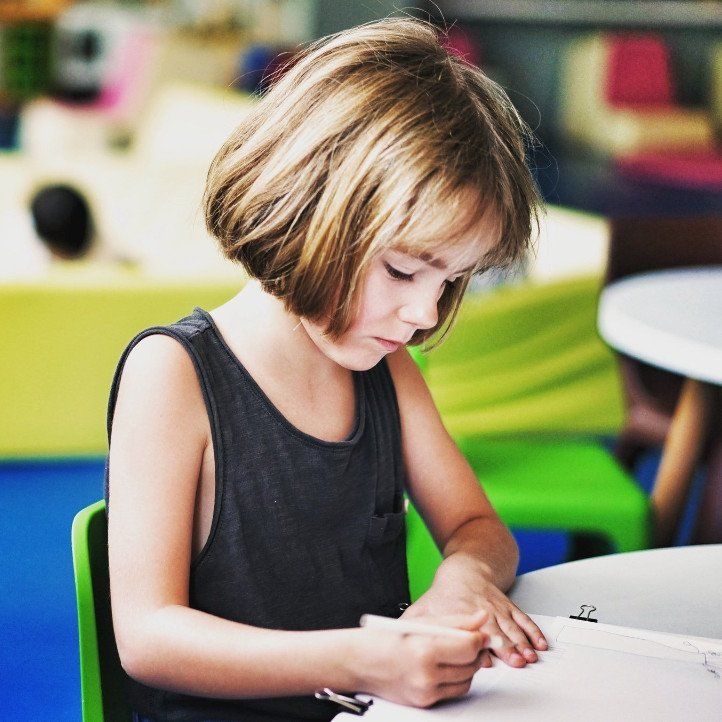 Stock photo of a young girl colouring on paper.