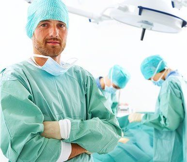 un medico in primo piano e due chirurghi