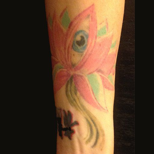 A woman has a tattoo of a pink flower on her arm.