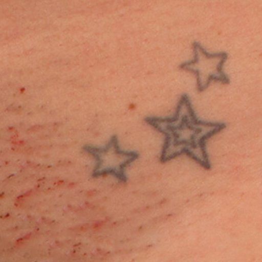 A close up of a tattoo of three stars on a person 's skin