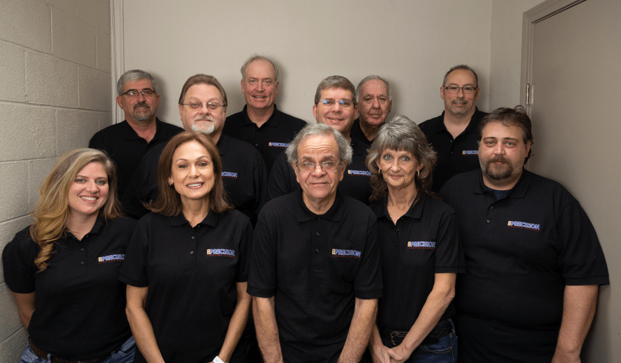 A group of people posing for a picture wearing black polo shirts